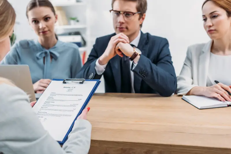 Selective focus of woman holding clipboard with resume