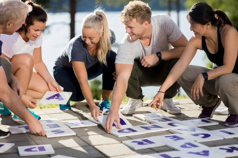 Business People Smiling While Solving Crossword puzzle