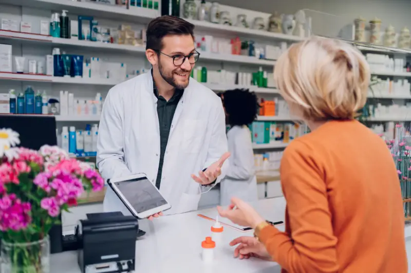 Portrait of a male pharmacist working at the counter in pharmacy