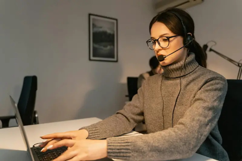 Woman in Gray Sweater Using a Laptop