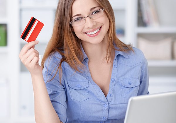 Young girl with laptop and credit card at home