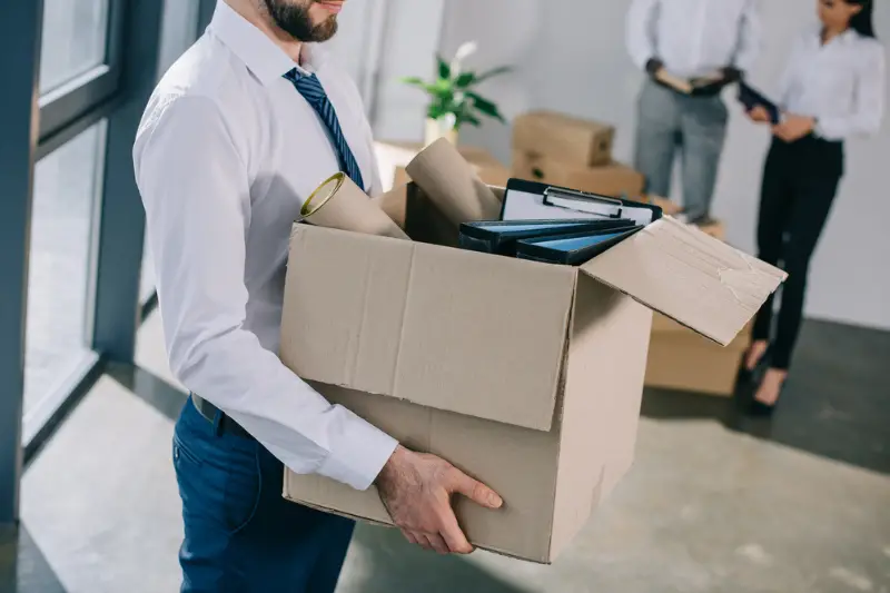 Male employee carrying box for office relocation