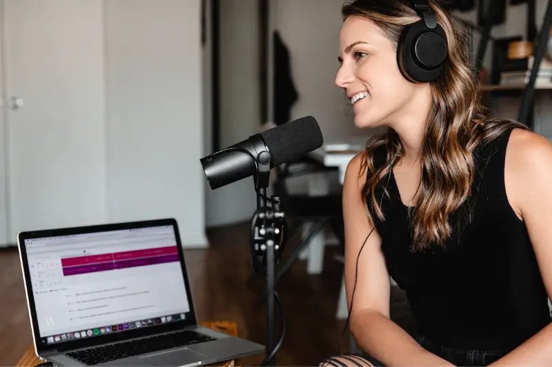 Women in black tank top sitting on chair in front of microphone