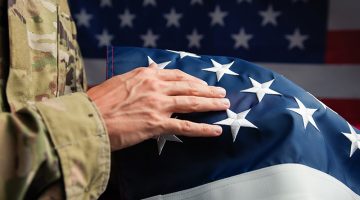 Hand of a Veteran touching stars of USA flag