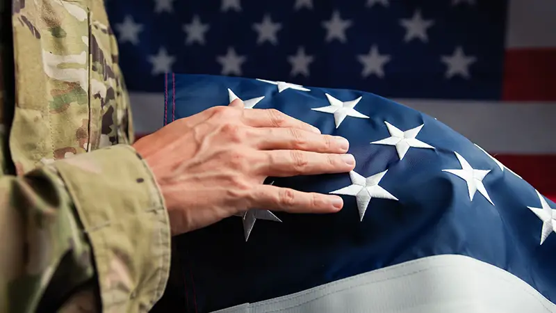Hand of a Veteran touching stars of USA flag