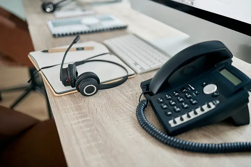 Telemarketing office, phone and VOIP on desk for communication