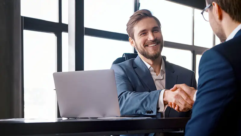 Young boss hiring new colleague shaking hands after successful job interview