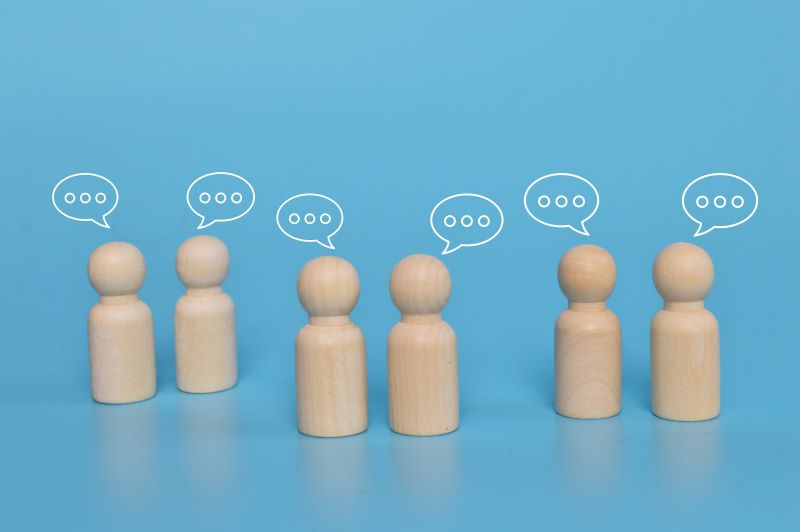 Wooden figure with notification icons of message, chatting social media interactions.