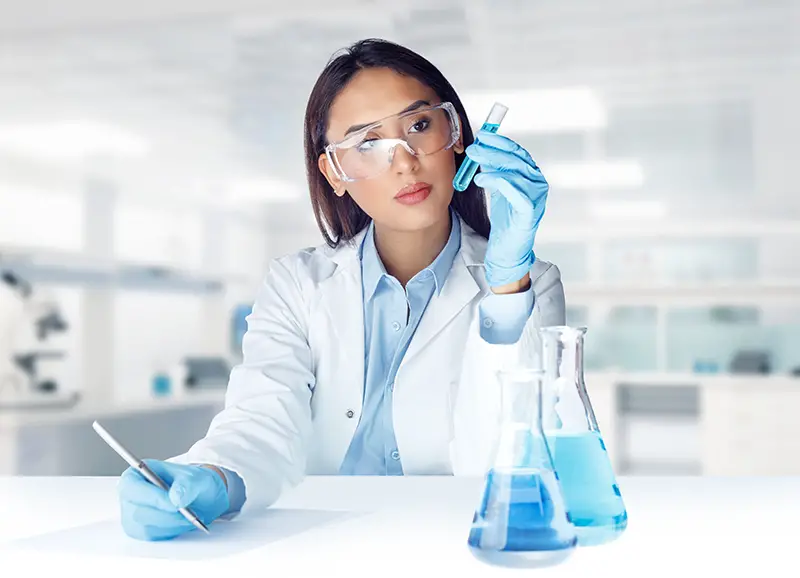 Female lab technician analyzing liquid sample