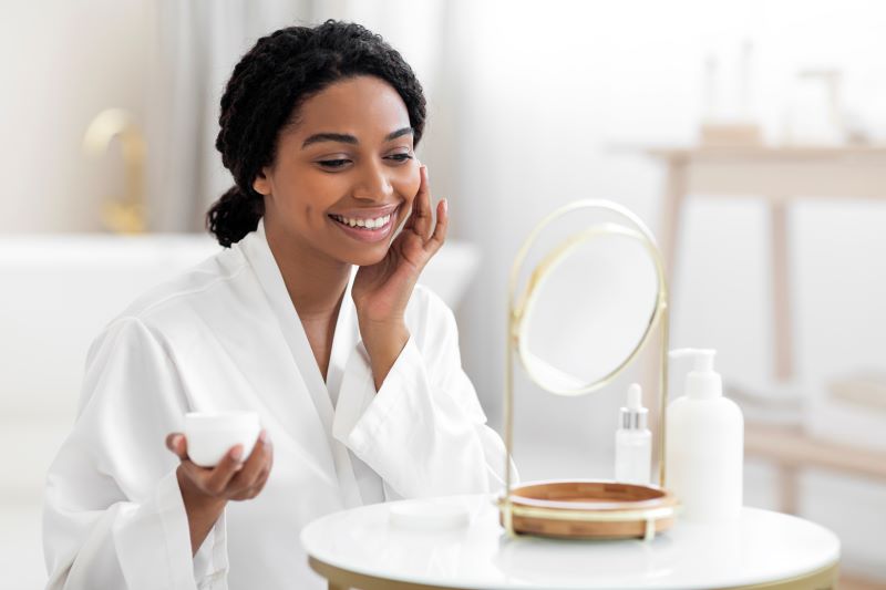 Attractive Black Woman Applying Moisturising Cream On Face