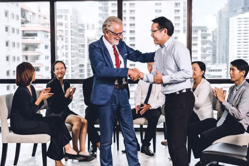 Image two business partners in elegant suit successful handshake
