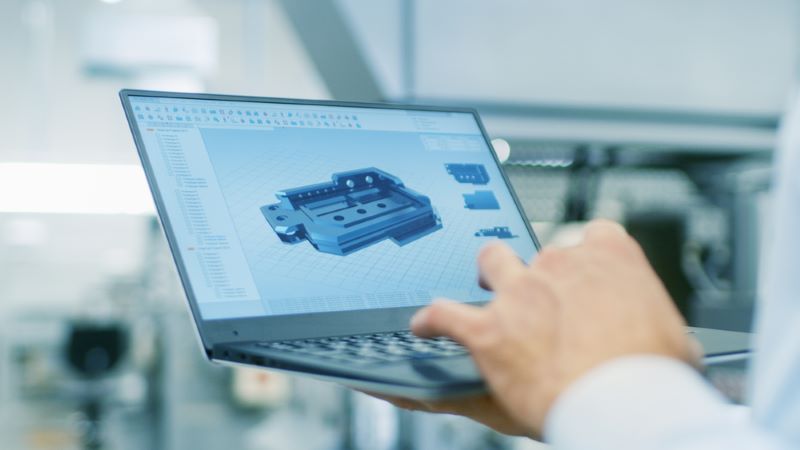 Close-up of the Engineer Holding Laptop with CAD component model on the screen