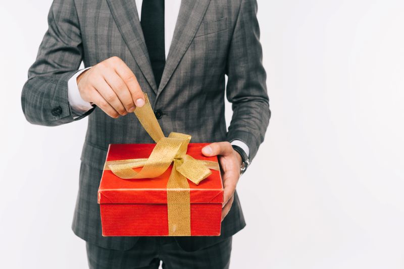 Cropped image of businessman opening gift box isolated on white background