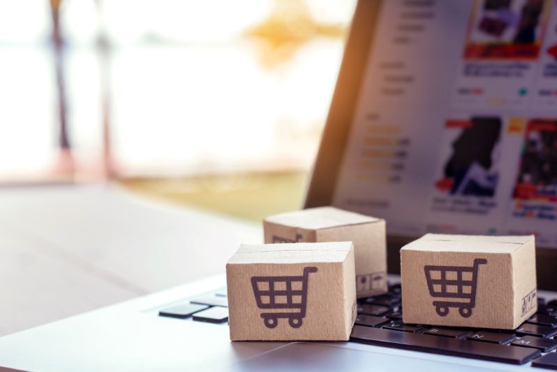 Shopping online. Cardboard box with a shopping cart logo