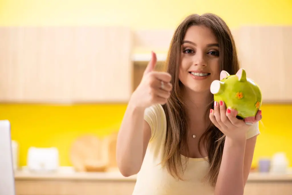 College student holding a piggy bank