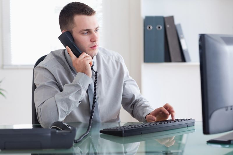 Businessman listening to caller while typing