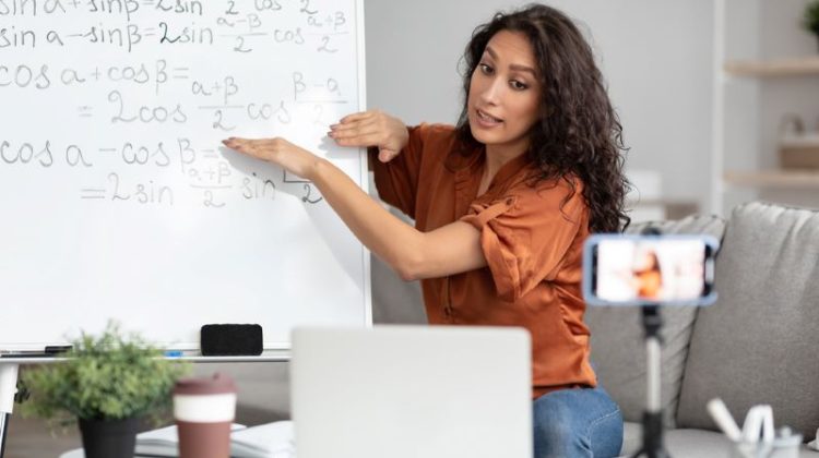 Math teacher showing board, giving virtual lecture to students