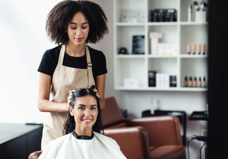 Beauty master making new hairstyle for young woman