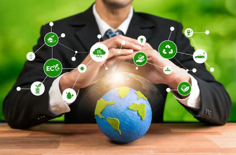 Businessman holding Earth with eco friendly icon