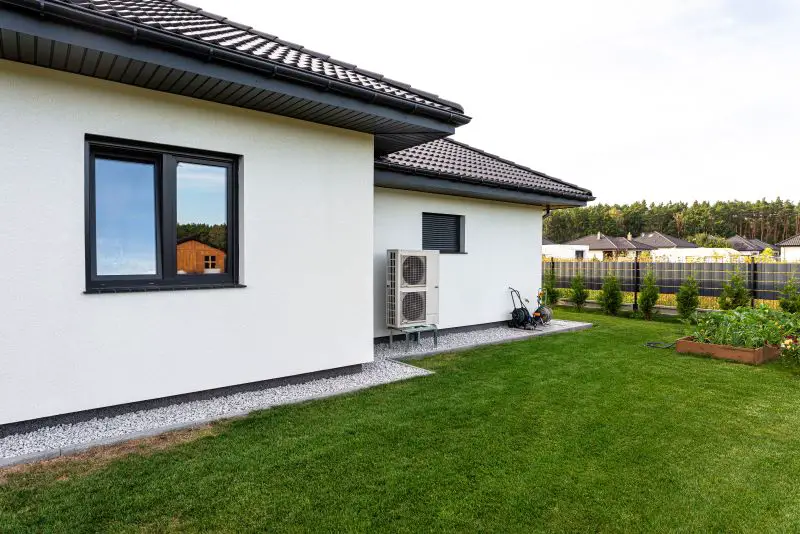 Two efficient outdoor air source heat pump units in front of the house.