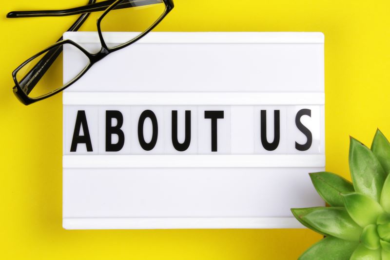 About us word on lightbox with succulent plant on yellow background