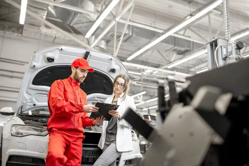 Woman client with auto mechanic at the car service