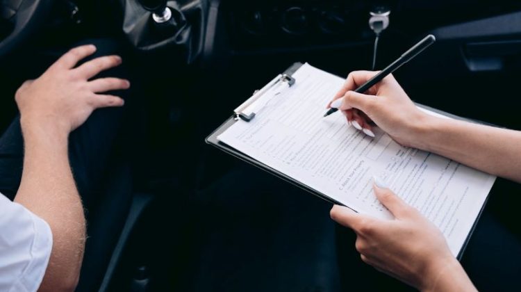 Person Writing on a Clipboard Inside a Vehicle