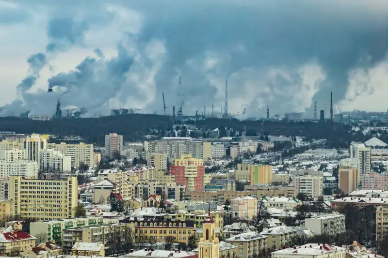 ariel panoramic view of city with huge factory with smoking chimneys in the background