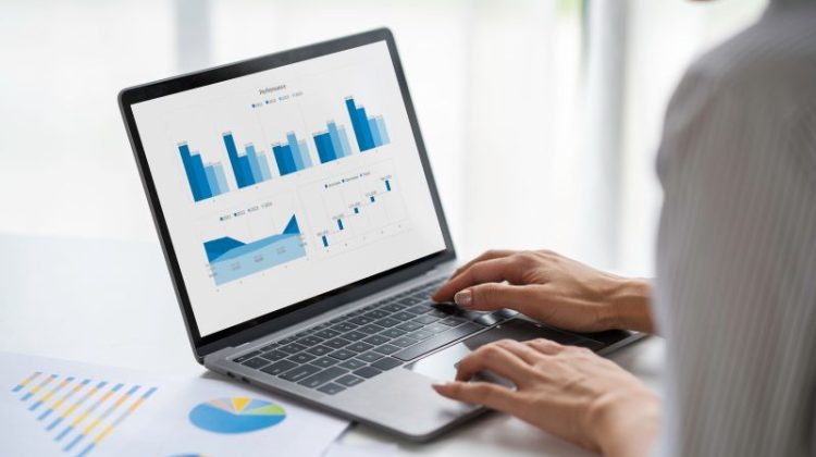 Investor reviewing adaptive investment strategy charts on a laptop, using real-time data analytics and performance metrics to inform portfolio decisions.