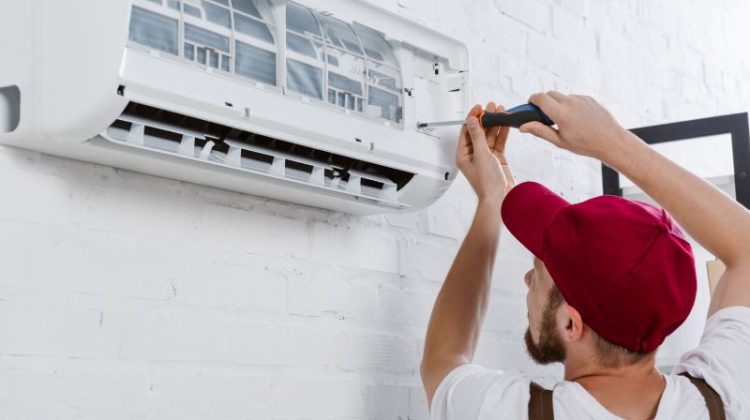 close-up shot of professional repairman changing filter for air conditioner with screwdriver
