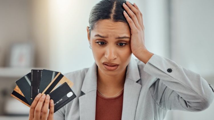 Worried businesswoman holding multiple credit cards while facing payment processor fund freeze issue
