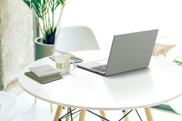 Acer Vero Laptop on a round table with mug and notebooks