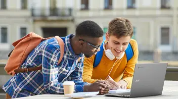 Two students studying together outside with an Acer Chromebook.