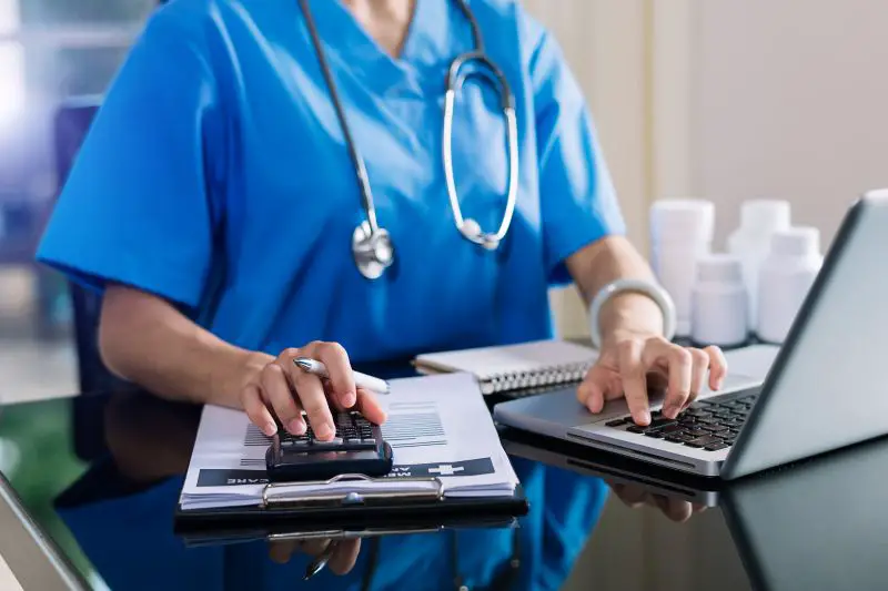 Healthcare costs and fees concept.Hand of smart doctor used a calculator and smartphone, tablet